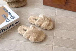 Dettaglio di pantofole in pelliccia sintetica per bambini con suole morbide e fasce.