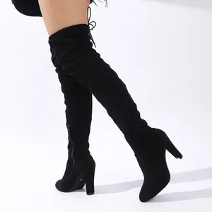 Detaillierte Seitenansicht eleganter schwarzer Overknee-Stiefel aus Wildleder mit Blockabsatz