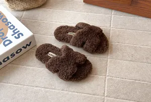 Dettaglio di comode pantofole marroni in peluche per bambini su un pavimento caldo