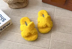Dettaglio di pantofole soffici giallo brillante con cinturini incrociati