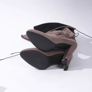 Detailansicht der schwarzen Blockabsätze und Sohlen der braunen Overknee-Stiefel aus Wildleder