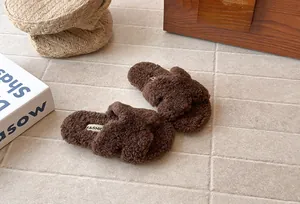 Vista dettagliata delle pantofole marroni soffici incrociate per bambini in ambiente accogliente