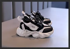 Πλαϊνή όψη ασπρόμαυρων chunky sneakers για κορίτσια με λεπτομέρειες από πλέγμα