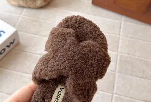 Primo piano della morbida texture in eco-pelliccia marrone di ciabatte bimbi