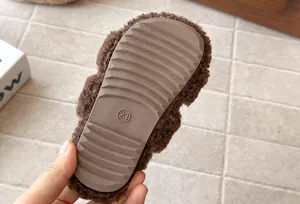Dettaglio della suola antiscivolo della pantofola in peluche marrone per bambini, taglia 23