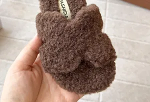 Dettaglio ravvicinato di pantofole in peluche marroni per bambini con texture morbida