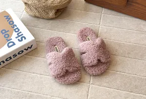 Vue détaillée de pantoufles roses pelucheuses pour filles avec semelle souple et brides