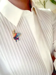 Elegant vintage enamel butterfly brooch with pearls pinned on a white pleated shirt.