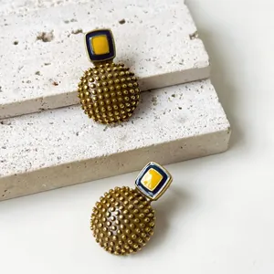 Vista detallada de pendientes de esmalte vintage con esfera de lunares en relieve