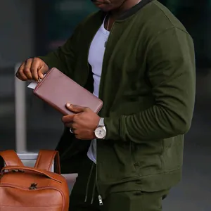 Detailansicht einer olivgrünen Herren-Sportjacke mit Reißverschluss und Rippbündchen.