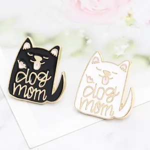 Close-up of black and white cartoon cat dog mom enamel pins on floral background