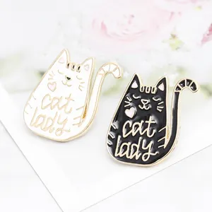 Detailed close-up of cute black and white cat lady enamel pins with gold trim and hearts