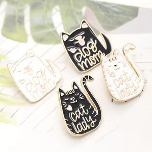 Detailed view of cat-shaped enamel pins featuring Dog Mom and Cat Lady text