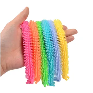 Close-up of colorful textured stretchy dinosaur toys held in hand for stress relief