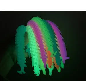 Close-up view of glow in the dark dinosaur stretchy noodle toys with neon illumination