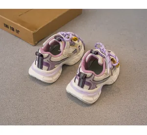 Vista trasera de zapatillas deportivas infantiles en malla transpirable morada y gris.