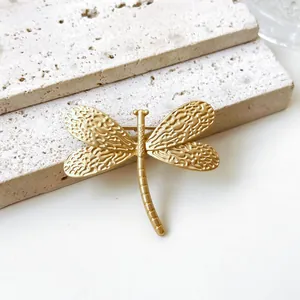 Detailansicht einer goldenen Vintage-Libellenbrosche mit strukturierter Oberfläche.
