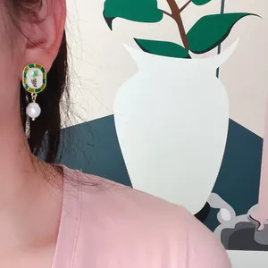 Vue détaillée des boucles d'oreilles vintage en émail de raisin avec perles baroques