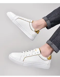 Λεπτομέρεια από λευκά δερμάτινα ανδρικά sneakers με χρυσές μεταλλικές λεπτομέρειες.
