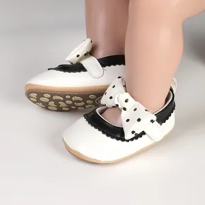 Detailed side view of white baby girl princess shoes with a cute black polka dot bow