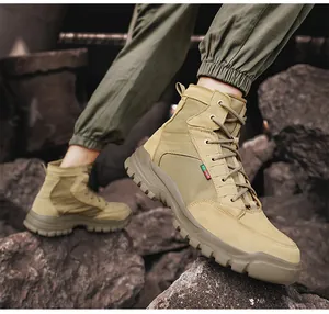 Detail view of men's tactical work boots in a rugged outdoor rocky environment.