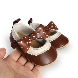 Macro detail of brown baby girl princess shoes with polka dot bow and scalloped trim