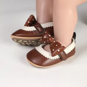 Adorable brown baby girl princess shoes with a polka dot bow for first walkers.