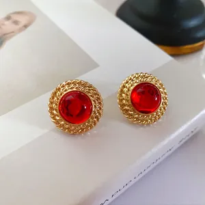 Gros plan de boucles d'oreilles vintage avec gemme rouge et bordure dorée