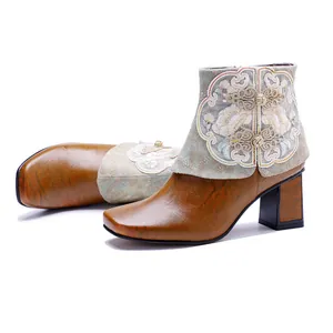 Detailed view of retro ethnic leather ankle boots with floral embroidery and chunky heels.