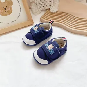 Close-up of cute bear character and velcro strap on blue baby walking shoes