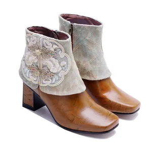 Detailed view of vintage ethnic leather boots with embroidered floral patterns and knots