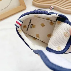 Interior detail of baby walking shoe showing bear pattern insole and size mark.