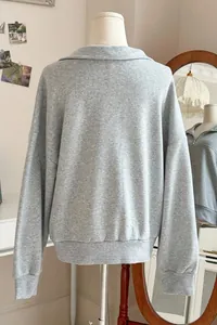 Rückansicht des grauen übergroßen Sweatshirts mit Polokragen und halbem Reißverschluss