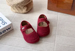 Dettaglio macro della texture in feltro rosso vino delle scarpe Mary Jane vintage da bambina
