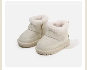 Close-up detail of children's fleece-lined winter snow boots in soft cream white color