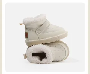 Close-up of off-white toddler winter snow boots with warm fuzzy lining and dot texture