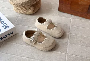 Dettaglio di scarpe Mary Jane in feltro beige per bambina con suola morbida e flessibile.