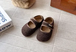 Primo piano di scarpe Mary Jane in feltro marrone retrò eleganti per bambina.