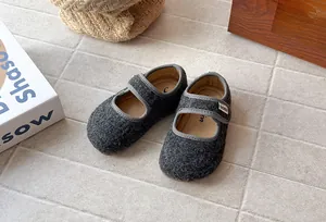 Dettaglio ravvicinato di scarpe Mary Jane in feltro grigio per bambine in stile retrò