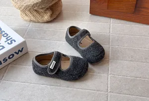 Primo piano delle scarpe Mary Jane in feltro grigio scuro per bambine, stile retrò chic