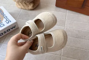 Primo piano di scarpe Mary Jane in feltro di lana beige con suola morbida e cinturino