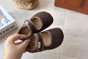 Primo piano di scarpe Mary Jane in feltro marrone per bambina con chiusura velcro