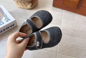 Dettaglio di scarpe Mary Jane in feltro grigio per bambini con chiusura velcro