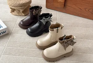 Detailed view of girls' leather Martin boots featuring elegant houndstooth bow accents