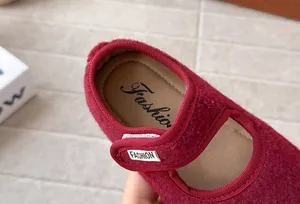 Dettaglio ravvicinato di scarpa Mary Jane rossa in feltro per bambina con cinturino velcro