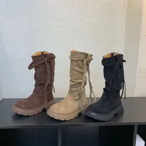 Detailed view of three vintage-style girls' high-top boots in brown, beige, and black.