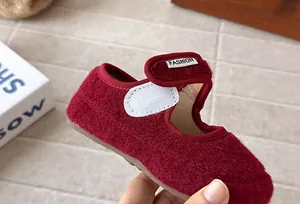 Dettaglio ravvicinato di scarpe Mary Jane in feltro rosso per neonata con cinturino