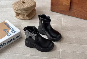Girls stylish black Martin boots featuring a checkered bow and convenient side zipper.