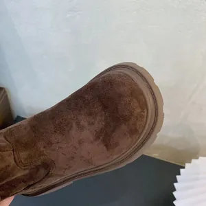 Macro detail of girls' brown suede high boots showing round toe and rubber sole