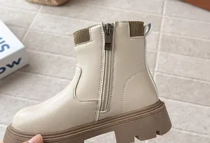 Close-up of girls' beige faux leather Martin boots with side zipper and thick sole.